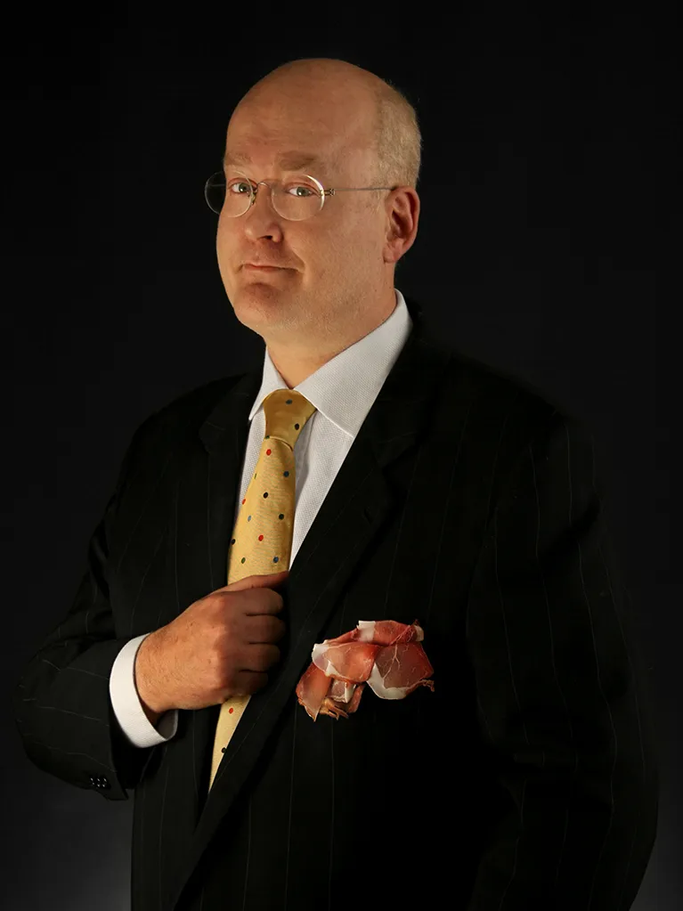 Foto di bob noto con cravatta e fetta di prosciutto in mano